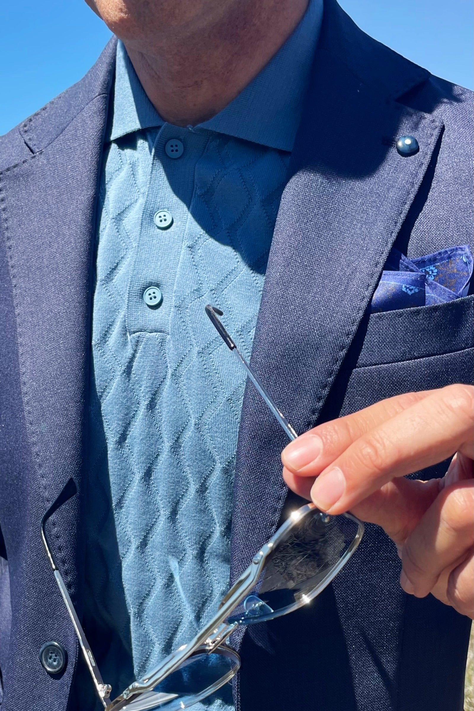 Americana azul marino con polo de punto para hombre y gafas. Estilo italiano.