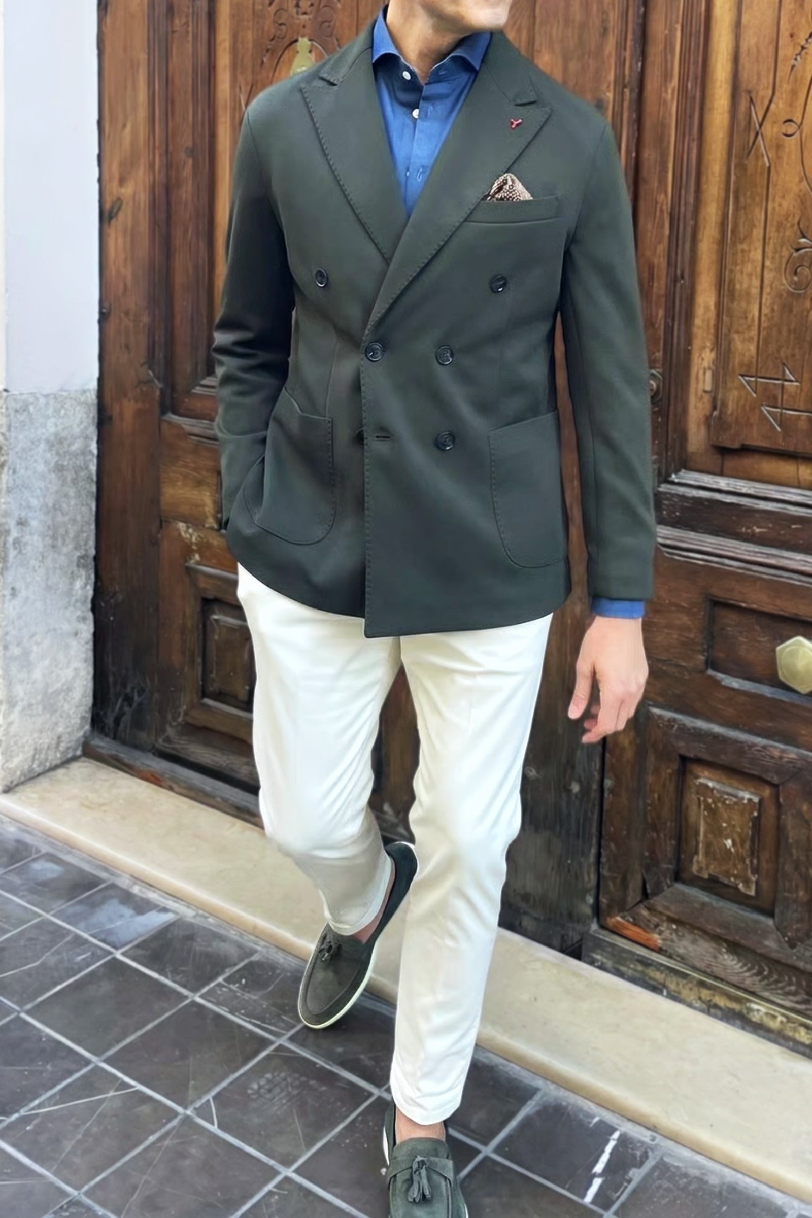 Outfit de hombre con americana cruzada verde combinada con pantalón claro y camisa vaquera