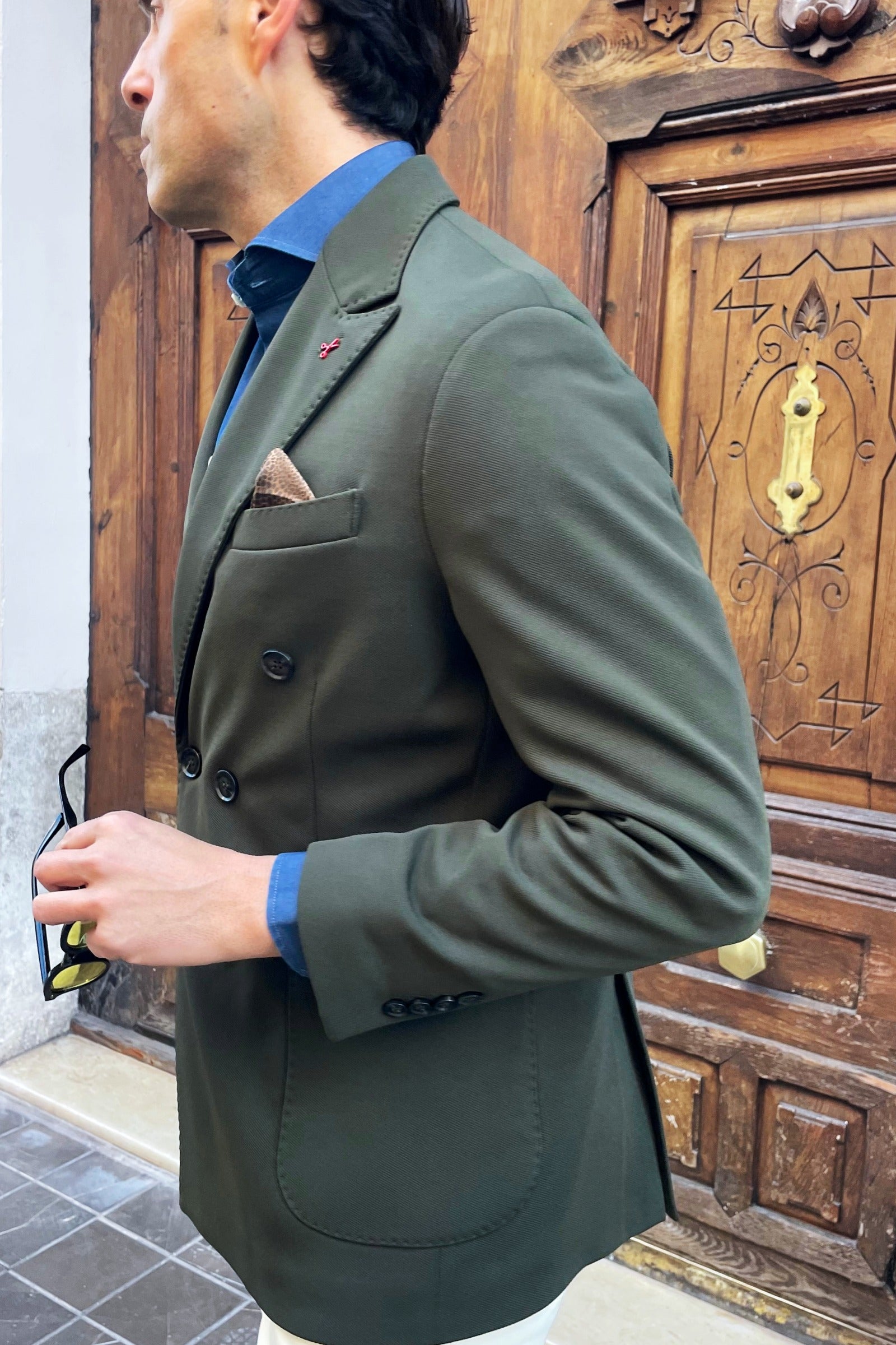 Vista lateral de americana cruzada verde para hombre con corte italiano