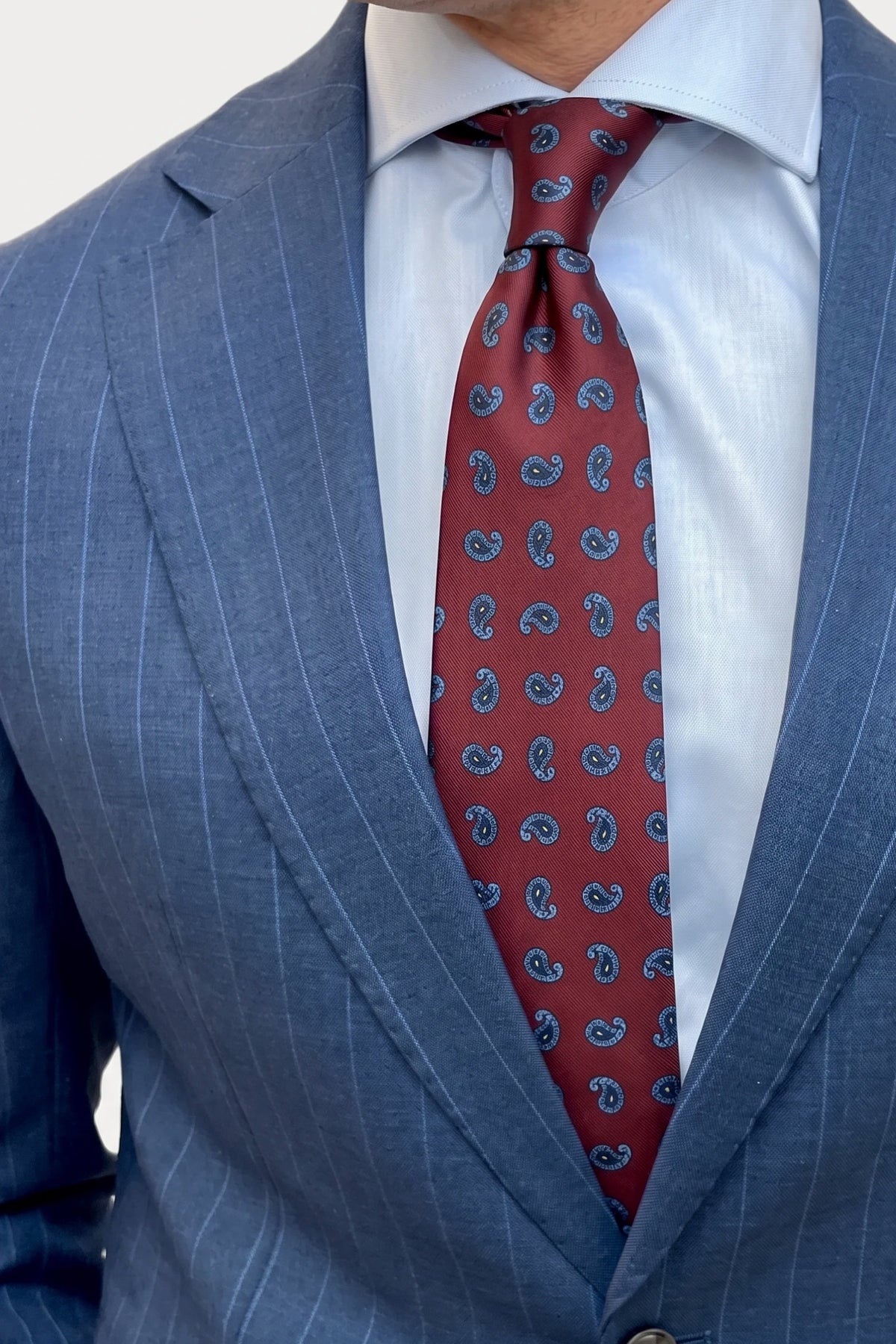 Corbata burdeos estampado Paisley, con traje azul italiano