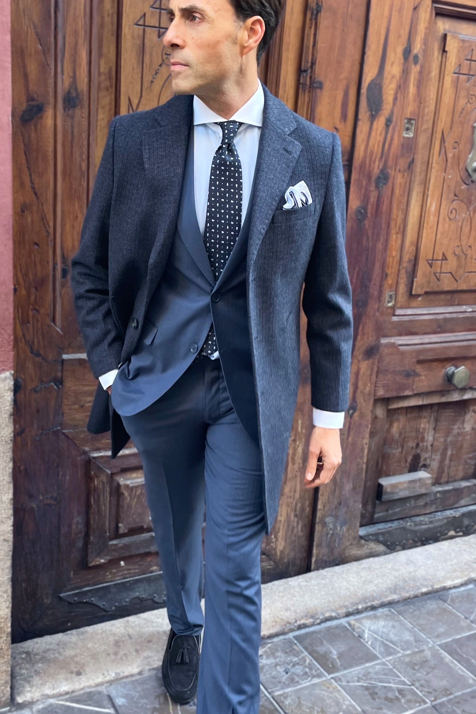 Outfit elegante con traje azul de vestir y abrigo para hombre con rayas sutiles y corte italiano